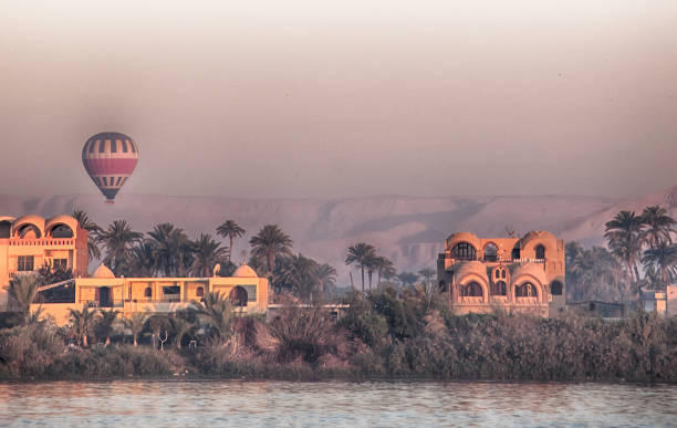 hot air balloons at sunrise seen from the banks of the Nile in Luxor